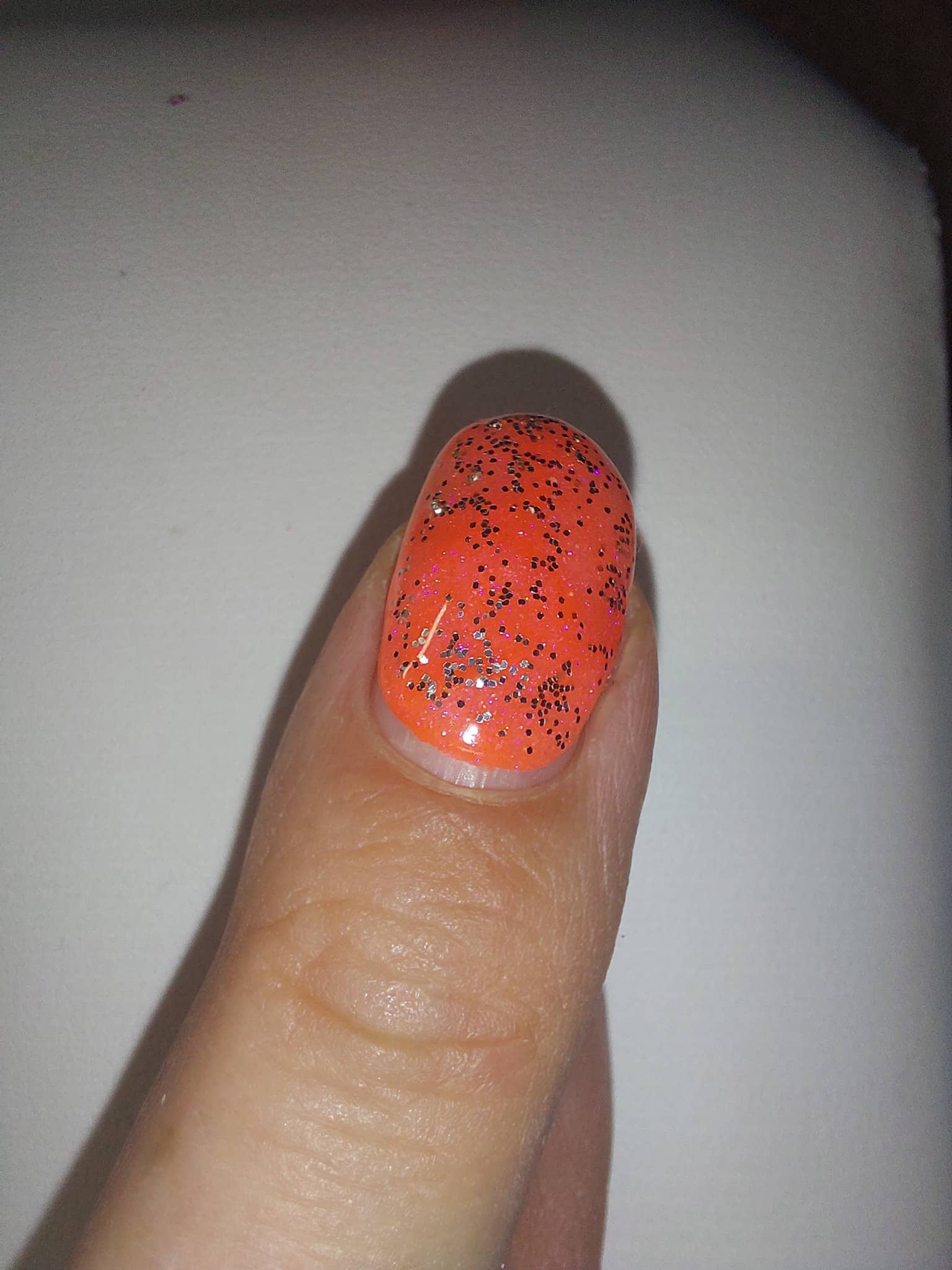 Ongle orange avec des paillettes Ongle orange avec des paillettes